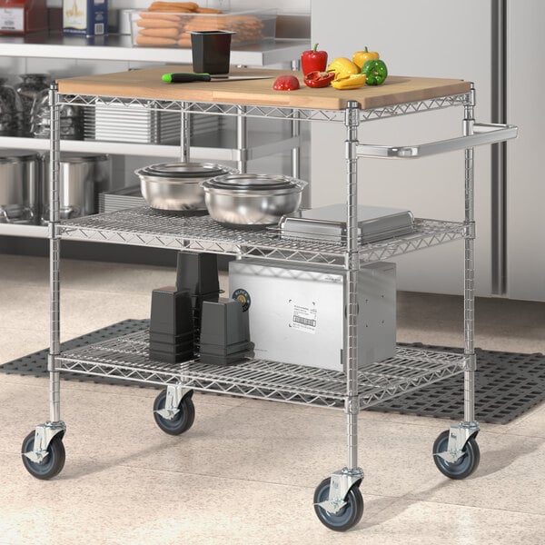 A Regency chrome utility cart with wooden shelves holding food.
