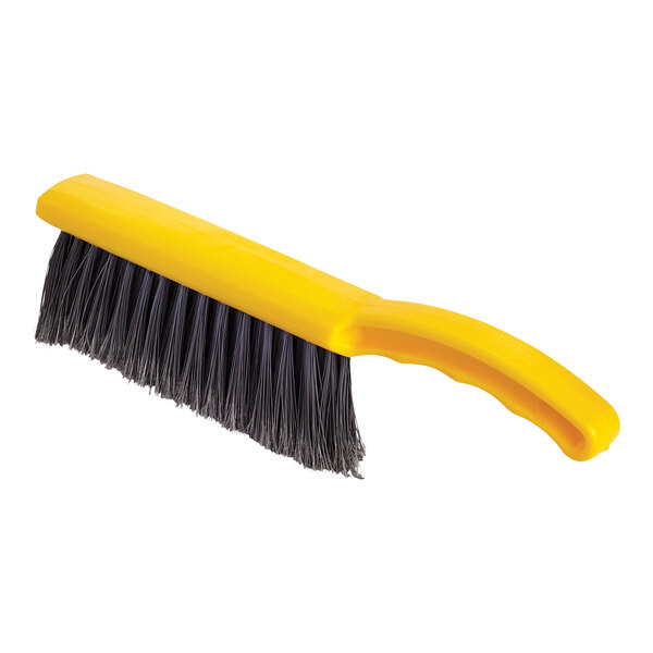 A close-up of a yellow Rubbermaid counter brush with black bristles.