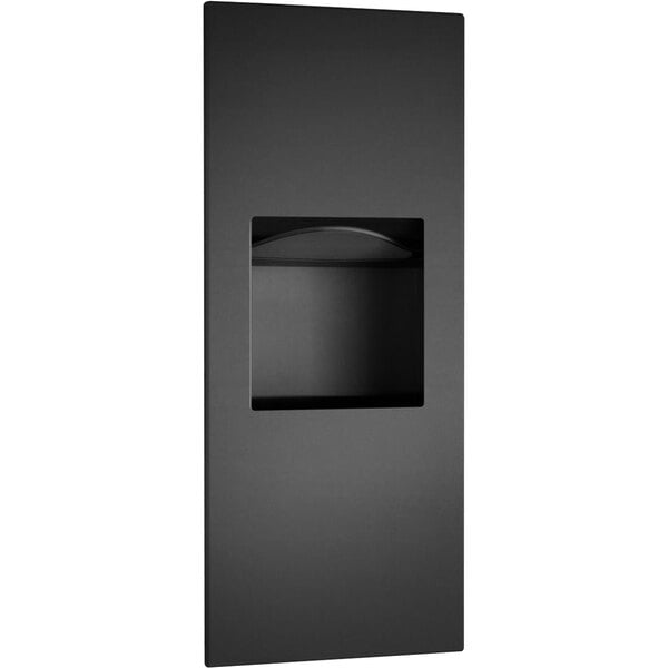 A black rectangular Bobrick paper towel dispenser with a hole in it.