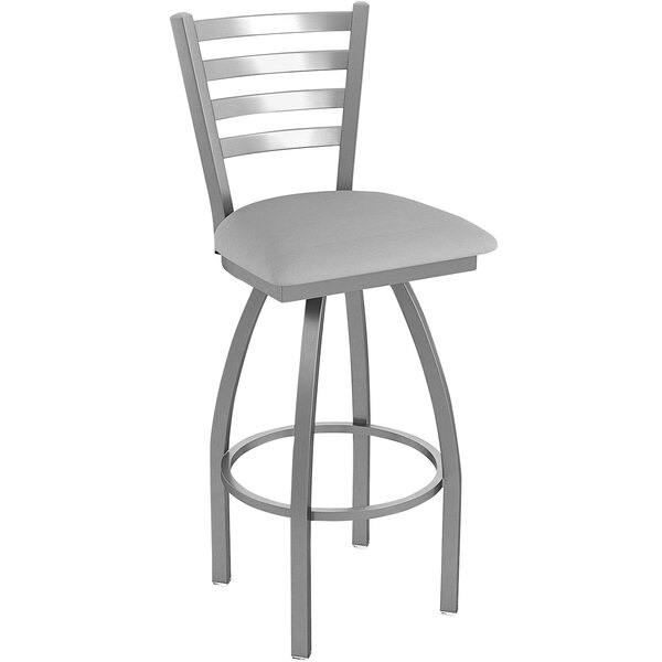 A grey Holland Bar Stool outdoor counter stool with a ladderback seat and cushion.