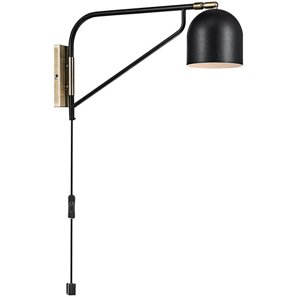 A Globe black and gold wall sconce with adjustable black shade over a table in a restaurant.