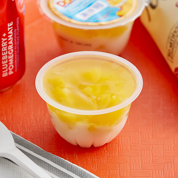 A Dole Peaches & Creme parfait in a plastic container with a red and white label.