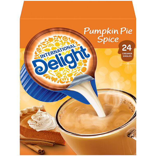 A package of International Delight pumpkin pie non-dairy creamer being poured into a cup of coffee.