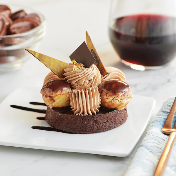 A plate of dessert with Valrhona milk chocolate and nuts with a glass of wine.