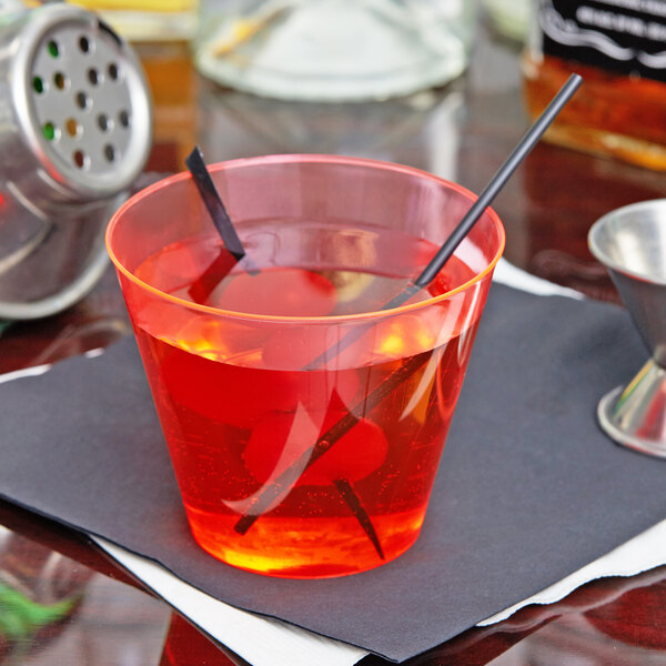 A red drink with black straws in a Fineline Savvi Serve plastic cup.