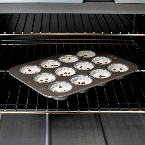 A Chicago Metallic muffin pan with frosted cupcakes in it.