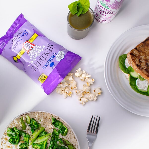 A plate of food with peas, broccoli, and a purple bag of Martin's Slender Pop Sea Salted Popcorn.