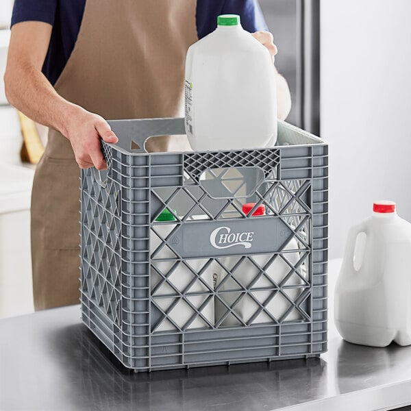 A man holding a milk jug in a Choice Grey Super Crate.