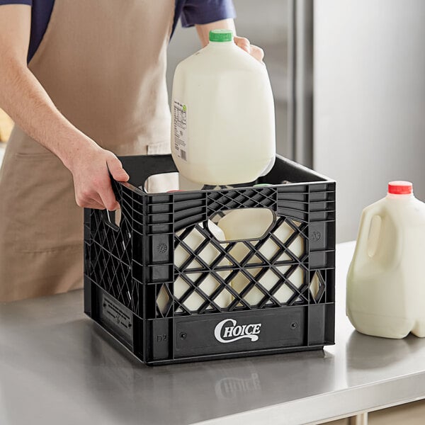 A person putting milk in a Choice black square milk crate.