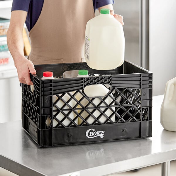 A man holding a milk jug in a black Choice rectangular milk crate.