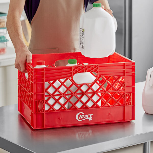 A man placing a jug of milk into a red rectangular plastic milk crate.