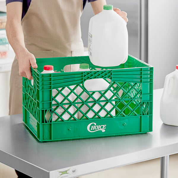 A person holding a milk jug in a green rectangular milk crate.