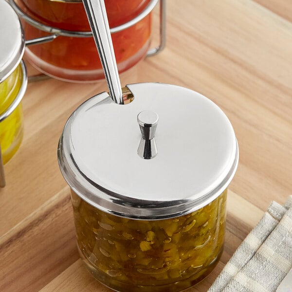 A Choice stainless steel lid on a 7 oz. glass jar of green relish with a spoon.