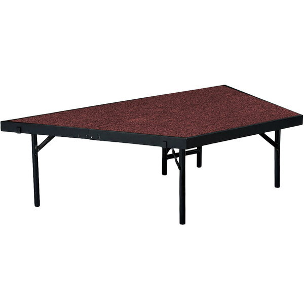 A National Public Seating pie-shaped stage unit with a red surface on a rectangular table.