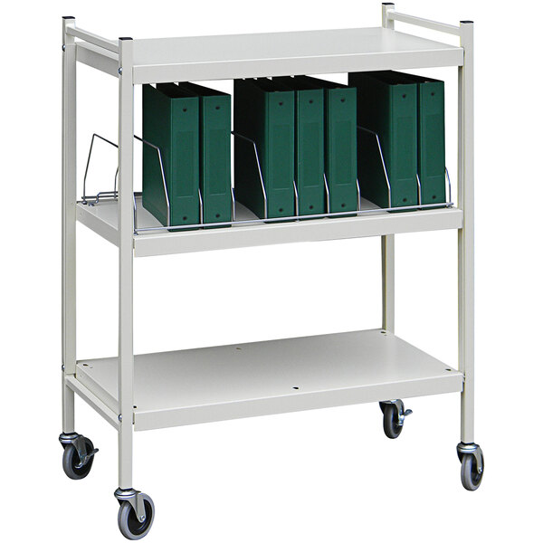 A light gray Omnimed medical cart with green binders on it.