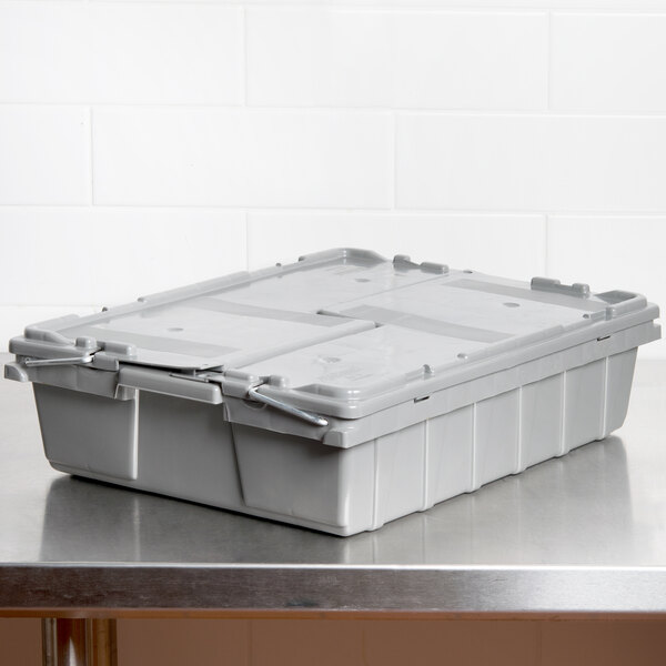 A gray plastic Vollrath Tote 'N Store container on a table.