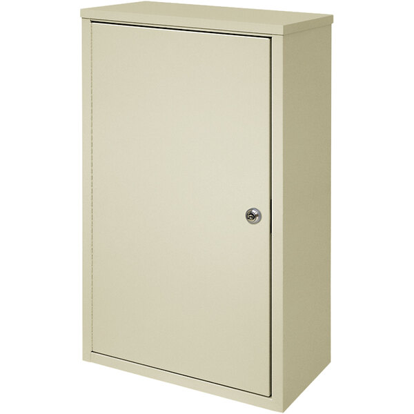 A beige metal Omnimed wall-mount storage cabinet with a door and key lock.