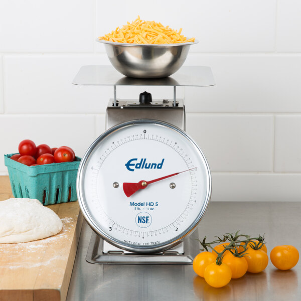 An Edlund heavy-duty portion scale with a bowl of tomatoes and cheese on top.