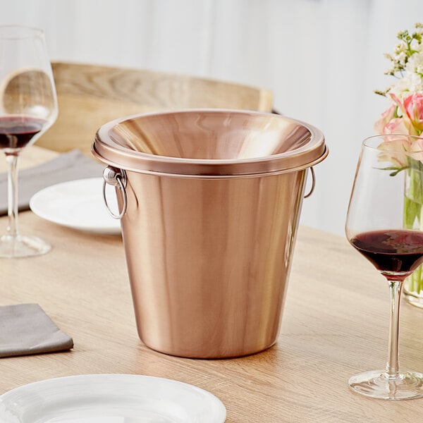 An Acopa copper wine tasting spittoon on a table in a winery cellar.