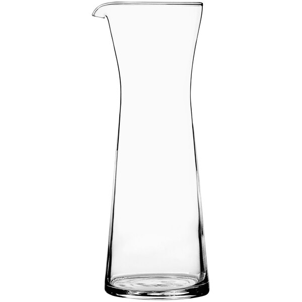 A clear glass carafe with a black handle.