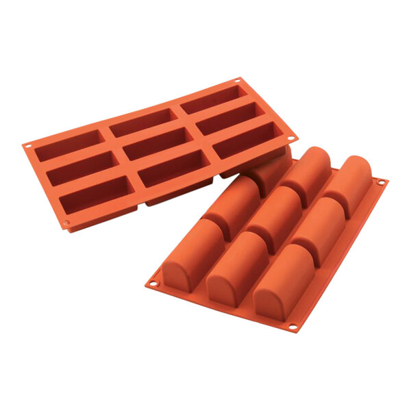 A close-up of a Silikomart silicone mold with nine log-shaped compartments.
