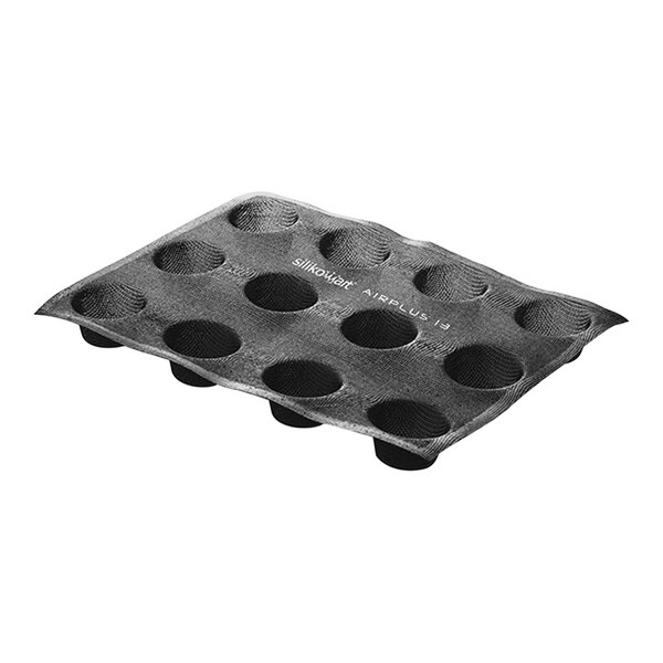 A black Silikomart baking mold with 12 oval cavities.