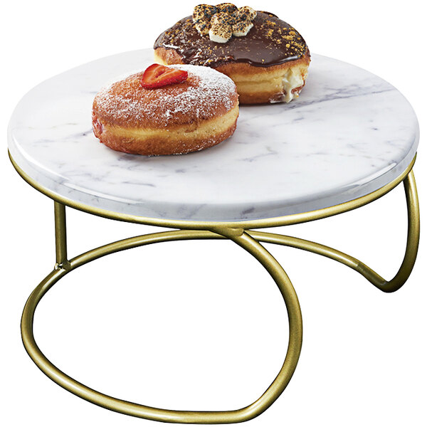 A donut with a strawberry on top on a Cal-Mil marble and gold display riser.