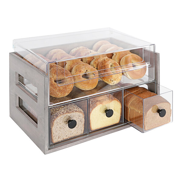 A Cal-Mil gray pine bread display case with bread and rolls in containers.