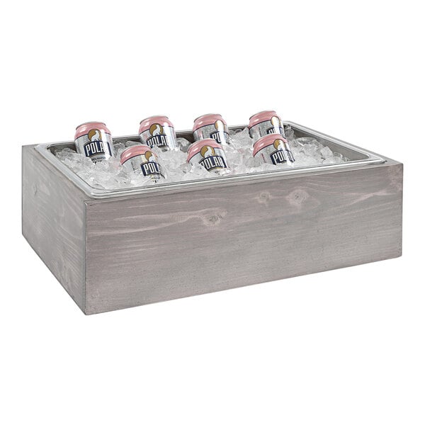 A Cal-Mil gray pine ice box with cans of beer in it.