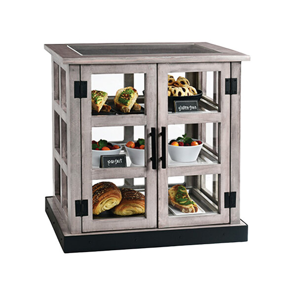 A Cal-Mil paneled bakery display case filled with food on a table.