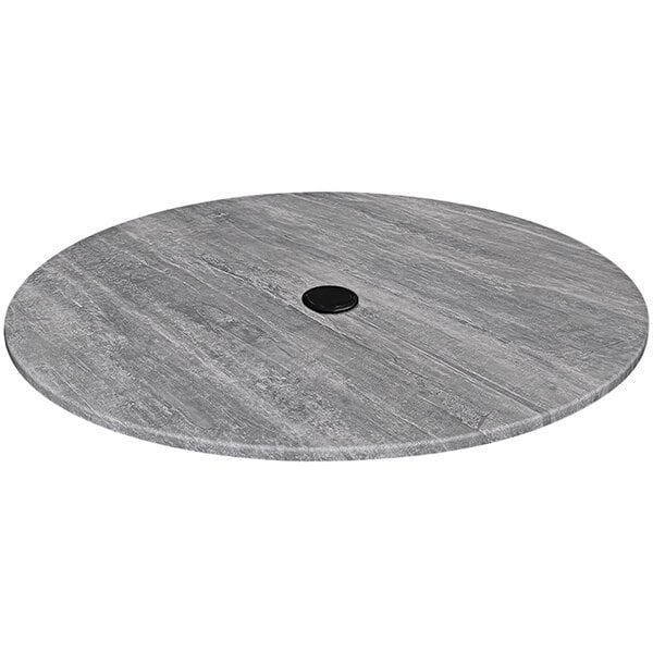 A round grey table top with a black circle and a hole in the middle.