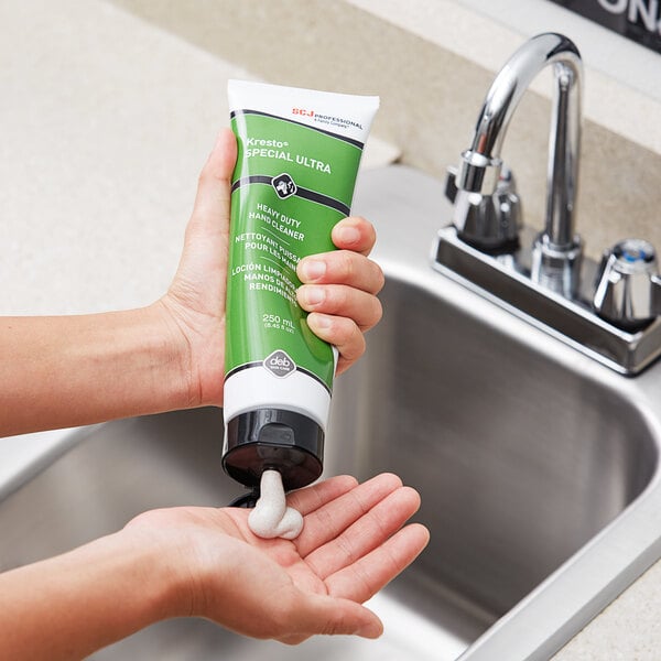 A person pouring SC Johnson Professional Kresto Special ULTRA hand cleaner from a green tube onto a hand.