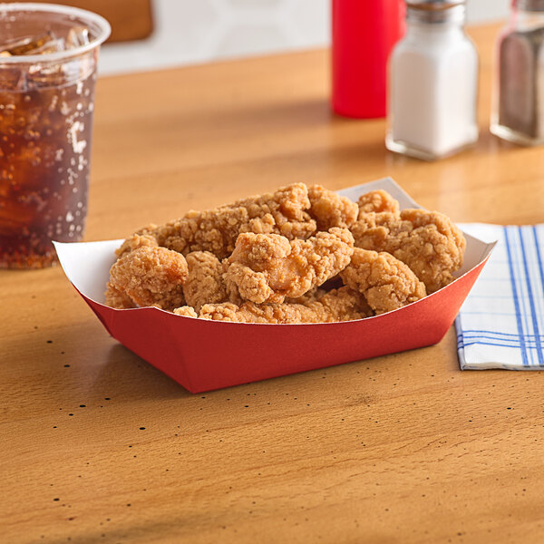 A red paper food tray with fried chicken on it.