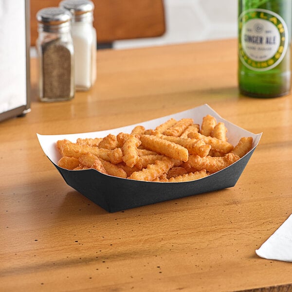 A paper tray of fries on a table.
