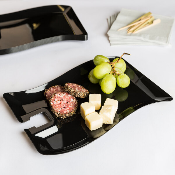 A black Fineline plastic cocktail plate with food on it.