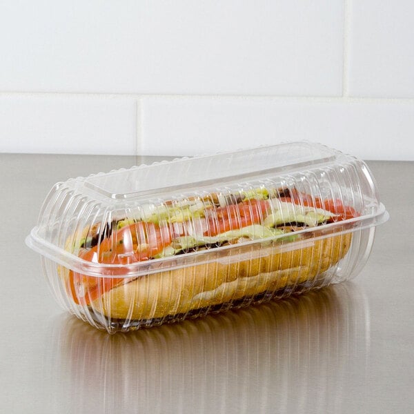 A sandwich in a Dart clear plastic hinged lid container on a counter.