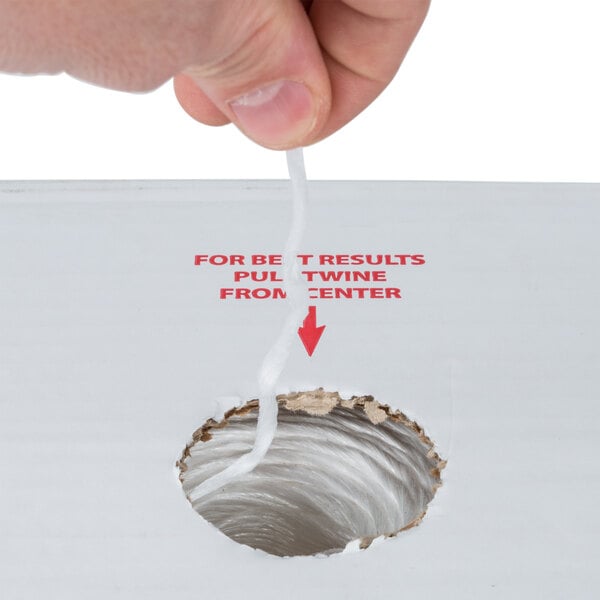 A hand pulling 1-Ply Polypropylene Industrial Twine from a hole in a cardboard box.