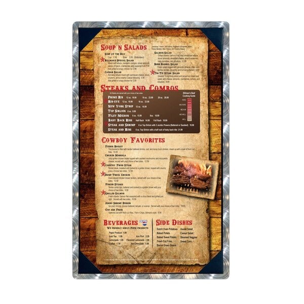 An Alumitique menu board with picture corners holding a menu for steaks and BBQ on a counter.