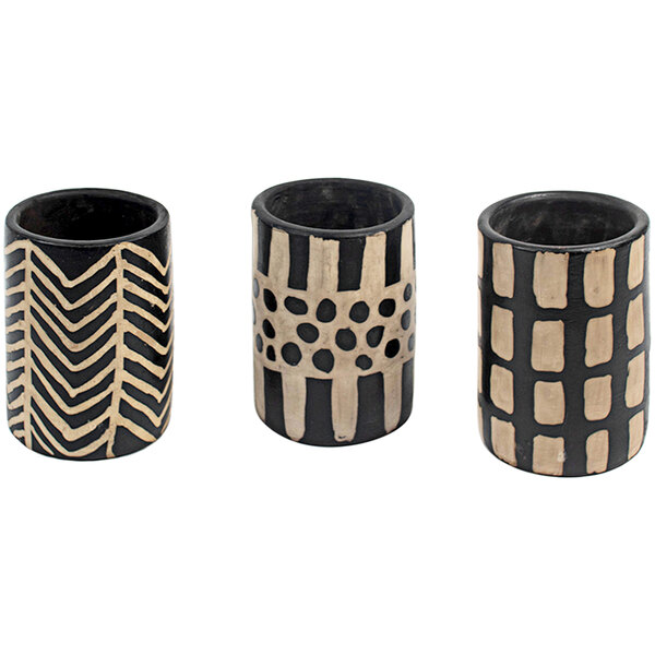 A group of three black and white clay cylinder vases with designs.