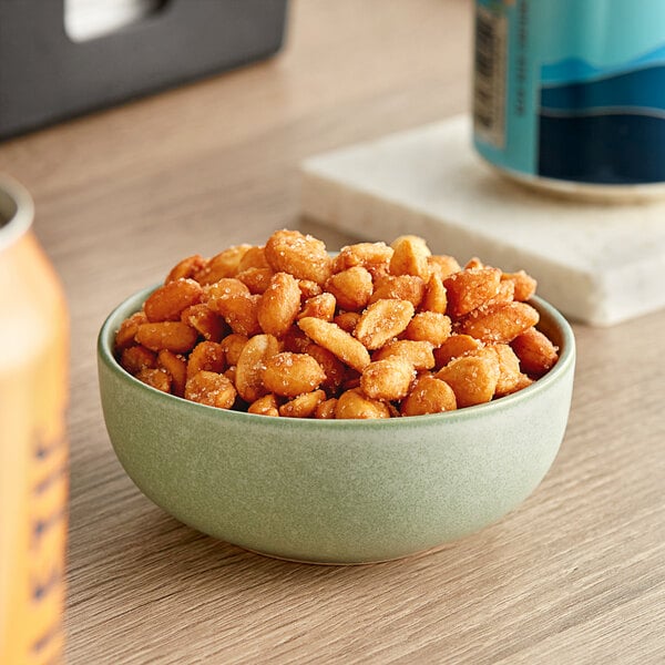 A bowl of Jumbo Honey Roasted Peanuts on a table.
