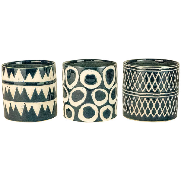 Three navy and white ceramic planters with geometric designs.