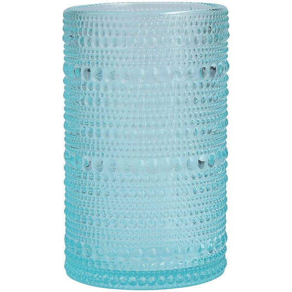A close up of a Fortessa Pool Blue beverage glass with a textured pattern.