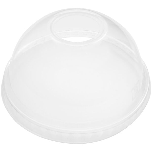 A clear plastic dome lid on a white surface with a hole.