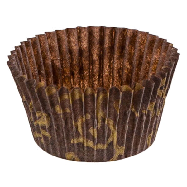 A close up of a brown paper Novacart cupcake wrapper with gold designs.