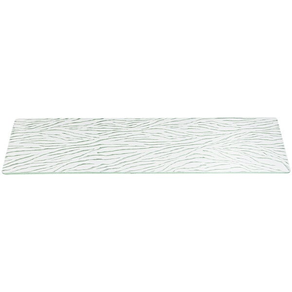 A white rectangular glass shelf with a pattern on it.