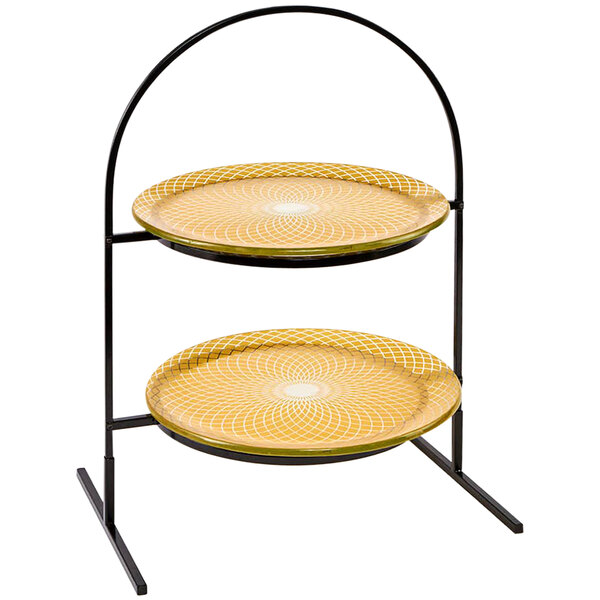 A Rosseto two tiered display stand with round gold platters on a table in a bakery.