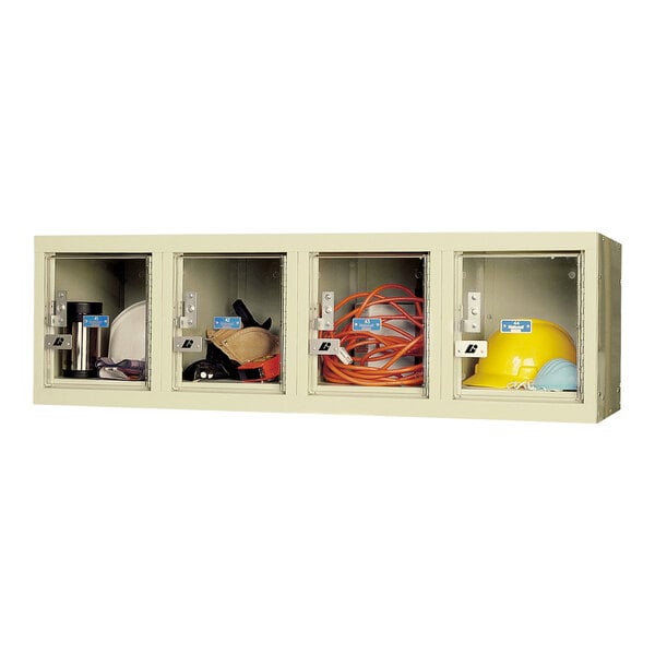 A tan wall mount box locker with four tiers holding various items.
