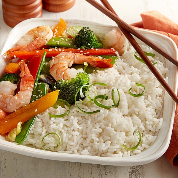 A white plate of Mandalay long grain rice with shrimp and vegetables.
