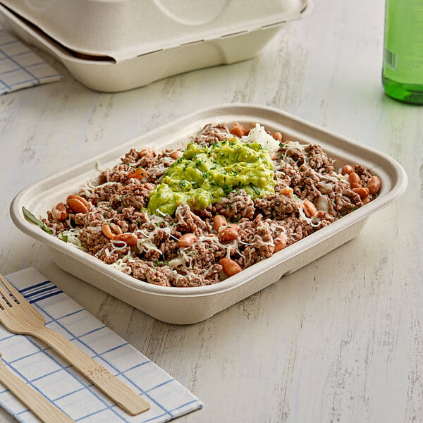 A World Centric compostable fiber container filled with food containing meat and vegetables.