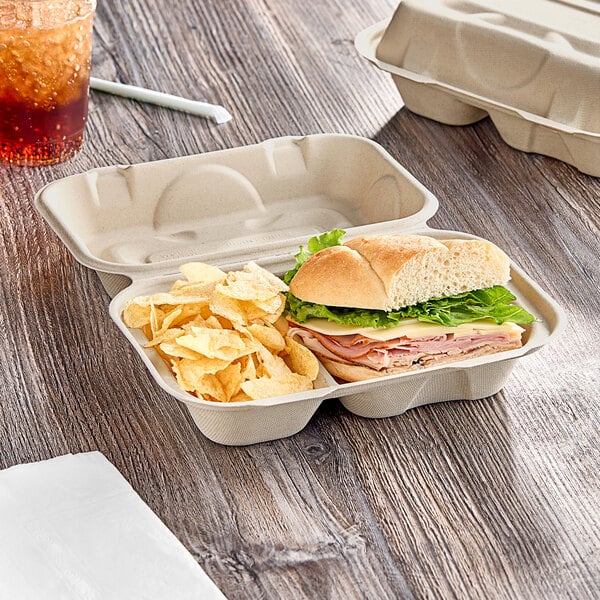 A World Centric compostable fiber hoagie clamshell with a sandwich and chips.